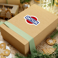 Load image into Gallery viewer, Datsun vintage logo sticker shown on a cardboard box
