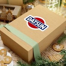 Load image into Gallery viewer, Datsun vintage logo sticker shown on a cardboard box
